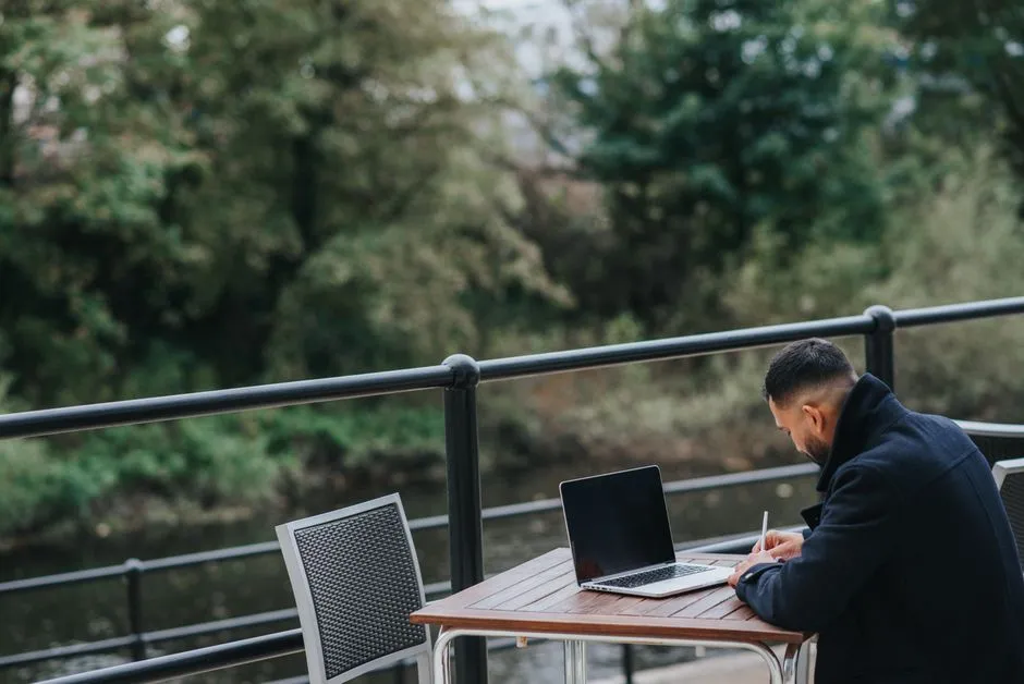 Person working on a laptop at an outdoor cafe table